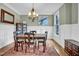 Elegant dining room featuring wainscoting, stylish chandelier, and rich hardwood floors at 204 Dartmoor Ln, Raleigh, NC 27614