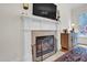 Classic white fireplace with mantle, decorative screen, and built-in storage, adding warmth and charm to the living space at 204 Dartmoor Ln, Raleigh, NC 27614