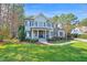 Beautiful exterior of home with lush landscaping and stone detailing; blue paint and black shutters at 204 Dartmoor Ln, Raleigh, NC 27614