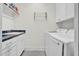 Well-equipped laundry room featuring modern washer and dryer units, sink, and storage shelves at 204 Dartmoor Ln, Raleigh, NC 27614