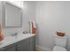 Bathroom featuring a gray vanity, neutral walls, a sink and a toilet at 205 Clancy Cir, Cary, NC 27511
