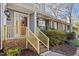 Charming front porch with brick steps, flowerpots, and newly renovated wooden handrail and post at 205 Clancy Cir, Cary, NC 27511