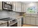 Bright kitchen with stainless steel appliances, granite countertops and white cabinets at 205 Clancy Cir, Cary, NC 27511