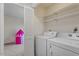 Laundry area features white washer and dryer units and storage shelves at 205 Clancy Cir, Cary, NC 27511