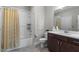 Well-lit bathroom featuring a shower over tub, single sink vanity, and modern finishes at 2104 Vandiver Way, Apex, NC 27523