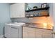 Laundry room with sink, counter space, shelves, and modern washer and dryer at 2104 Vandiver Way, Apex, NC 27523