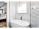 Contemporary bathroom showcasing a standalone tub and a large window for natural light at 222 Friesan Way, Rolesville, NC 27571