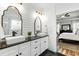 Stylish bathroom boasting dual vessel sinks, black countertops, and views into main bedroom through doorway at 222 Friesan Way, Rolesville, NC 27571