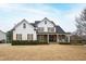 Beautiful two-story home with white siding, stone accents, black roof and inviting front porch at 222 Friesan Way, Rolesville, NC 27571