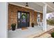 Detailed view of the front porch, featuring a wreath, rocking chairs, stone accents and planters at 222 Friesan Way, Rolesville, NC 27571