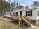 Charming yellow home with a wooden deck and black shutters, nestled among tall trees at 248 Dutches Ln, Henderson, NC 27537