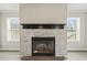 Cozy fireplace with stone surround and black mantel, flanked by windows at 248 Dutches Ln, Henderson, NC 27537