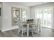 Bright dining area with wood-look flooring, a modern table set, and sliding door access to the outdoors at 26 Artesa Ct, Fuquay Varina, NC 27526