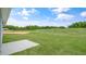 Expansive green backyard with a concrete patio and a treeline beyond at 267 Palm Dr, Sanford, NC 27332