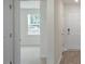 Bright hallway featuring wood-look flooring and neutral walls, leading to a room with a window at 267 Palm Dr, Sanford, NC 27332