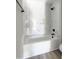 Modern bathroom features a soaking tub, white marble tile surround, and black fixtures at 307 7Th St, Butner, NC 27509