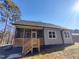 Back exterior with screened in porch, gray siding and dark roof at 307 7Th St, Butner, NC 27509