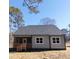 Back exterior with screened in porch and gray siding at 307 7Th St, Butner, NC 27509
