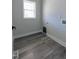 Small laundry room with hardwood floors, base trim, and a single window for natural light at 307 7Th St, Butner, NC 27509