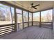 Screened-in porch with a ceiling fan overlooking the backyard and mature trees at 307 7Th St, Butner, NC 27509