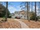 Backyard with trees and rocky lawn leading to a two-story home at 3659 Coach Lantern Ave, Wake Forest, NC 27587