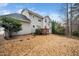 View of the backyard of a two-story home with a rock lawn and a small back deck at 3659 Coach Lantern Ave, Wake Forest, NC 27587
