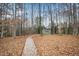 Backyard shed surrounded by lush woods accessed by a gravel path at 3659 Coach Lantern Ave, Wake Forest, NC 27587