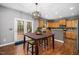 Dining area featuring hardwood floors, large dining table, and access to outdoor space at 3659 Coach Lantern Ave, Wake Forest, NC 27587