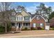 Classic two-story home with a covered front porch and mature trees in a well-manicured front yard at 3659 Coach Lantern Ave, Wake Forest, NC 27587