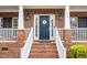 Close-up of the home's front door with brick steps, white railings and classic design at 3659 Coach Lantern Ave, Wake Forest, NC 27587