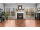 Bright living room with fireplace, mantle and decorative mirror between two windows at 3659 Coach Lantern Ave, Wake Forest, NC 27587