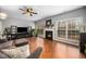 Inviting living room with a fireplace, large windows, and gleaming hardwood floors at 3659 Coach Lantern Ave, Wake Forest, NC 27587