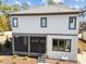 Rear exterior view featuring a screened in porch, yard with young trees, and house with a gray roof at 3727 Bellevue Rd, Raleigh, NC 27609