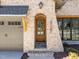 Close-up of the brick entryway featuring a charming arched wood front door with glass panes at 3727 Bellevue Rd, Raleigh, NC 27609