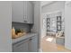 Mud room with grey cabinets, light hardwood floors, and a bench at 3727 Bellevue Rd, Raleigh, NC 27609