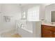 Bathroom featuring a soaking tub, white paneling and a large mirror at 38 Parkside Dr, Lillington, NC 27546