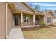 Cozy front porch with brick columns, hanging plants, and decorative landscaping at 38 Parkside Dr, Lillington, NC 27546