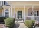 Inviting front porch with welcoming decor, green door, and manicured shrubs at 3809 Volkswalk Pl, Raleigh, NC 27610