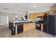 Efficient kitchen offering wood cabinets, black appliances, and an open layout into the living room at 3809 Volkswalk Pl, Raleigh, NC 27610