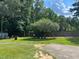 Expansive backyard featuring a mature tree, storage buildings, and a fenced perimeter at 412 Nc-82, Dunn, NC 28334