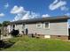 Home exterior featuring siding, a metal roof, grill, and grassy backyard at 412 Nc-82, Dunn, NC 28334
