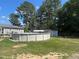 Grassy backyard featuring an above-ground pool, wooden deck, and shed at 412 Nc-82, Dunn, NC 28334