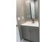 Modern bathroom featuring a gray vanity, large mirror, updated lighting, and vinyl flooring at 471 Merriman St, Henderson, NC 27536