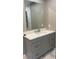 Bathroom vanity with gray cabinets, marble countertop, and a large framed mirror at 471 Merriman St, Henderson, NC 27536