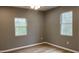 Cozy bedroom featuring natural light with two windows and wood-look flooring at 471 Merriman St, Henderson, NC 27536