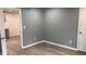 Neutral painted room with LVP flooring, white trim and baseboards, a double electric outlet and a door at 471 Merriman St, Henderson, NC 27536