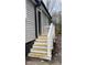 Side door entryway with new wood stairs and white railing to make the entryway accessible and safe at 471 Merriman St, Henderson, NC 27536