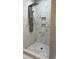 This marble shower features gray fixtures, updated showerhead, and built-in toiletry coves at 471 Merriman St, Henderson, NC 27536