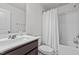 Bright bathroom featuring a single sink vanity with a large mirror and a shower/tub combo with white tiles at 5818 Humanity Ln, Raleigh, NC 27616
