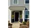 Charming home exterior featuring a covered front door entrance, stylish planters, and clearly visible house number at 5818 Humanity Ln, Raleigh, NC 27616